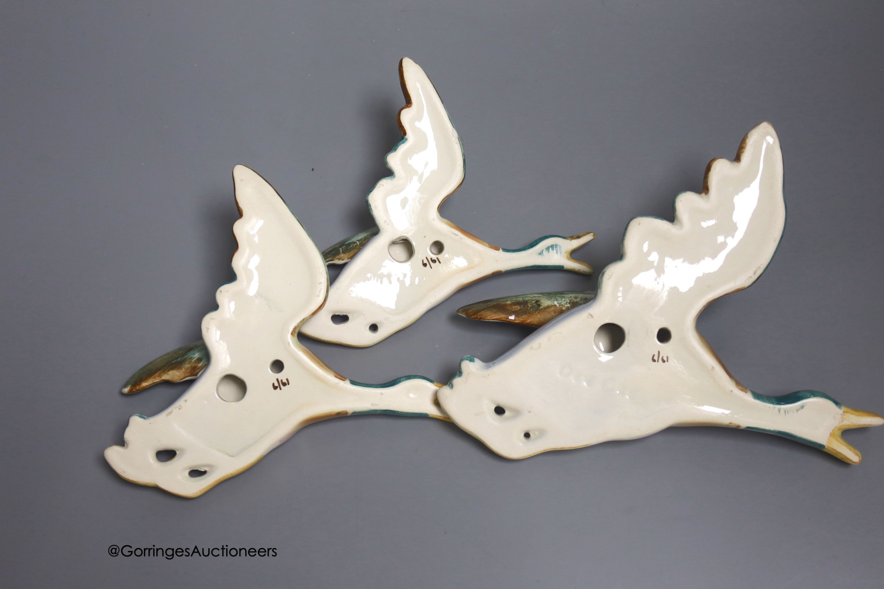 A graduated set of three earthenware wall-hanging flying ducks, widest 20cm